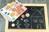 Foto: Tafel mit Kinderzeichnung darauf und Bargeld